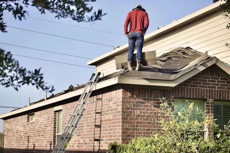 Professional roofer working on a residential roof in Cedmont